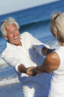 Happy Senior Couple Playing Holding Hands on A Tropical Beach