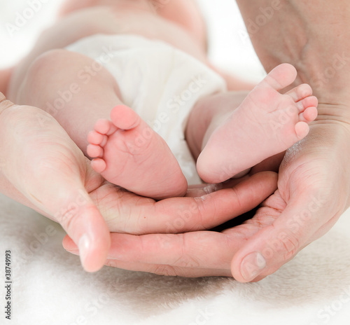 Photo: close up of a father's hand and babies feet close up of a father's hand and babies feet