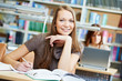 young student girl working with book at library