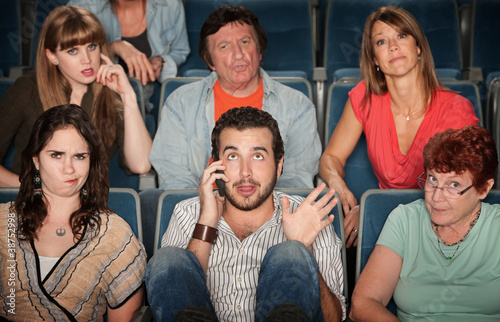 Photo: Man On Phone In Theater Man On Phone In Theater