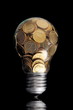 Traditional glass bulb with many golden coins on black Traditional glass bulb with many golden coins on black