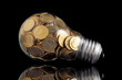 Traditional glass bulb with many golden coins on black Traditional glass bulb with many golden coins on black