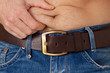 Photo: Mann kneift sich in den Bauch - Diat, Abnehmen Mann kneift sich in den Bauch - Diat, Abnehmen