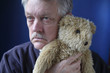 senior man holding teddy bear senior man holding teddy bear