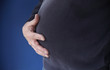 man with hands on his overweight belly man with hands on his overweight belly