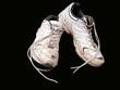 Alte Sportschuhe vor schwarzem Hintergrund