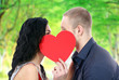 Happy couple with heart kissing outdoors Happy couple with heart kissing outdoors
