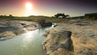 Kids washing clothes in a river at sunset in Kenya.