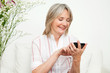 Seniorin spielt Online-Spiel auf Handy