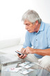 Senior am Laptop mit Taschenrechner