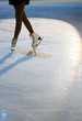 Woman’s Legs in White Ice Skates