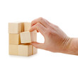 The hand establishes a wooden cube