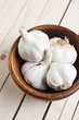 Wooden bowl with heads of garlic