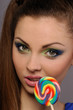 young girl sucks sweet on stick