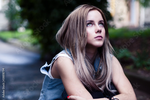 Photo: a beautiful young girl sitting sadly a beautiful young girl sitting sadly