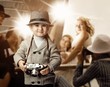 Baby boy with retro camera over photo shoot background.