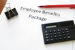 employee benefits package with calculator and pen