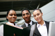 Foto: low angle shot of young colored trio in office low angle shot of young colored trio in office