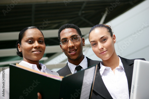 Photo: low angle shot of young colored trio in office low angle shot of young colored trio in office