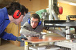 worker showing an apprentice how using the machine