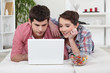 Young couple watching a film on their laptop Young couple watching a film on their laptop