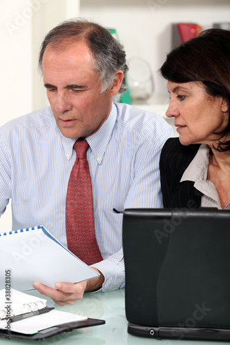 Photo: Business couple working at a desk Business couple working at a desk
