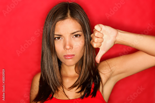 Photo: Unhappy thumbs down woman Unhappy thumbs down woman
