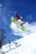 Snowboarder jumping against blue sky