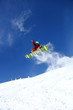 Snowboarder jumping against blue sky