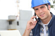 Foto: Construction worker using a mobile phone Construction worker using a mobile phone