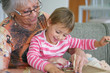 Photo: Grandma and granddaughter playing a game Grandma and granddaughter playing a game