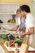couple cooking together in kitchen