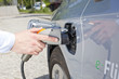 Foto: Tankstutzen und Zapfpistole bei einem Elektroauto Tankstutzen und Zapfpistole bei einem Elektroauto