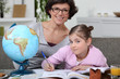 Little girl doing homework with her mom
