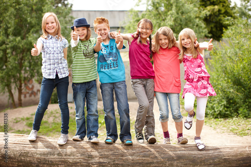 Foto: Gruppe fröhlicher Kinder auf Baumstamm Gruppe fröhlicher Kinder auf Baumstamm