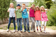 Gruppe fröhlicher Kinder auf Baumstamm
