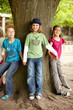 Gruppe Kinder stellen sich um einen Baum