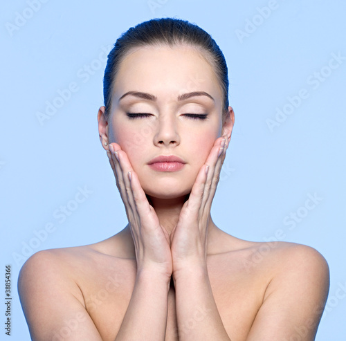 Photo: face of beautiful teen girl touching her cheeks face of beautiful teen girl touching her cheeks