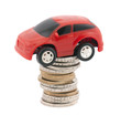 Red toy car on stack of euro coins