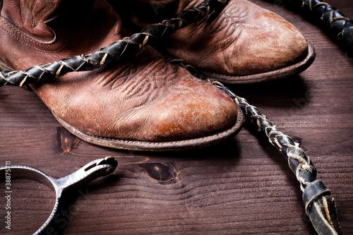 Photo: Cowboy boots whip and spurs on wood Cowboy boots whip and spurs on wood