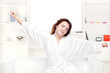 Foto: girl in bathrobe at home stretching arms girl in bathrobe at home stretching arms