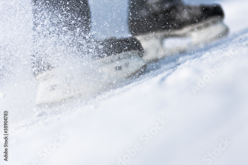 Photo: Snow flying from braking, ice skates blurred Snow flying from braking, ice skates blurred