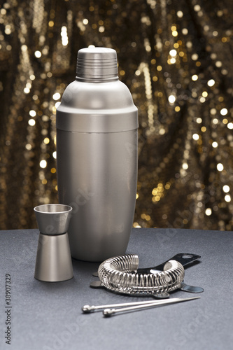 Photo: Bartender tools in front of a gold glitter background Bartender tools in front of a gold glitter background