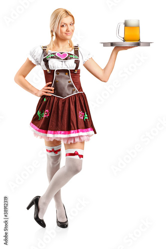 Photo: Woman wearing traditional costume and holding a tray with beer g Woman wearing traditional costume and holding a tray with beer g