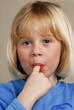 Niña comiendo chocolate chupando dedos.