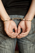 Criminal hands locked in handcuffs