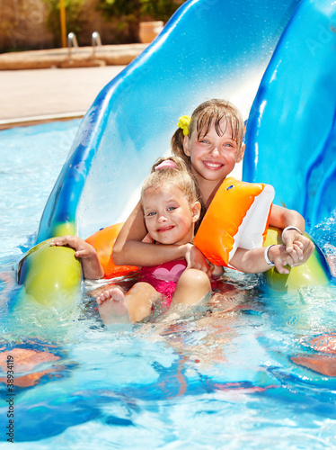 Photo: Children on water slide at aquapark. Children on water slide at aquapark.