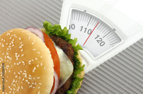 Foto: Burger on a weight scale Burger on a weight scale
