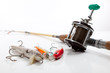 Fishing rod and three lures on a white background