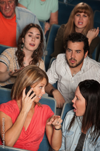 Photo: Women On Phone in Theater Women On Phone in Theater